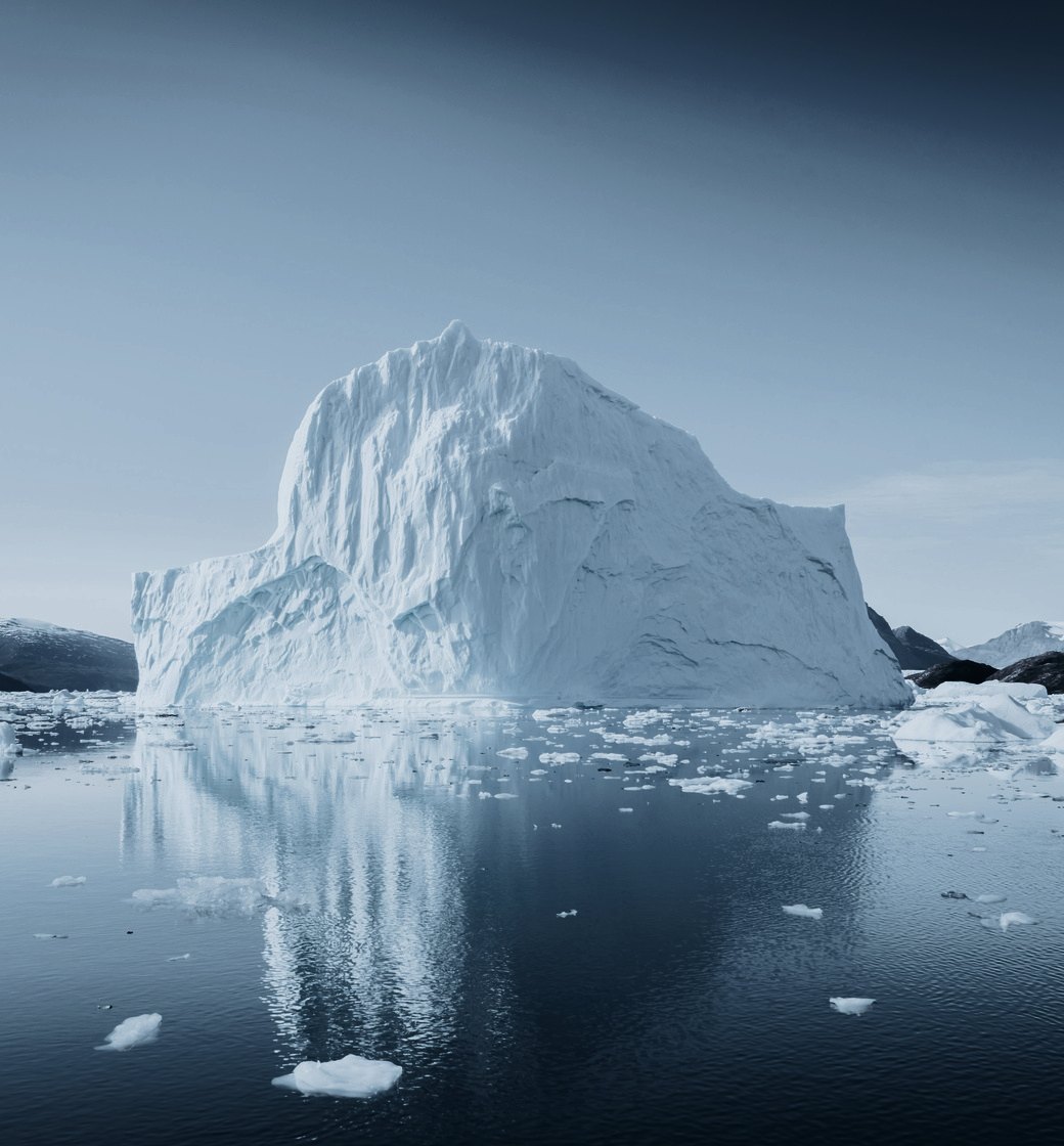 An iceberg reflected in still, dark water